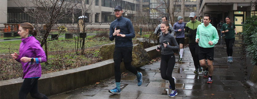 Staff and students running through Chancellor's Court on University of Leeds campus