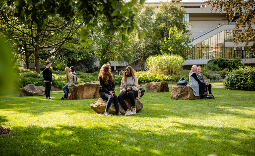 People sat in Chancellor's Court talking in the sun